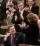 In the House of Commons, a man is sitting while his fellow politicians are standing and applauding.